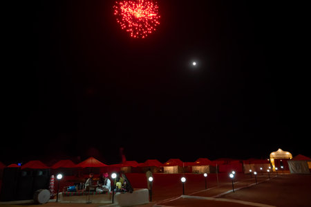 Thar desert,Rajasthan, India - October 15th 2019 : Rajasthani folk singers are singing folk songs in cultural program at desert camp site.Fire crackers are bursting in moonlit desert horizon at night.のeditorial素材