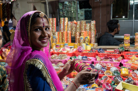 Jodhpur, Rajasthan, India - 18.10.2019 : Smiling Rajasthani woman trying out colorful bangles. Bangles being sold at famous Sardar Market and Ghanta ghar Clock tower in Jodhpur, Rajasthan, India.のeditorial素材