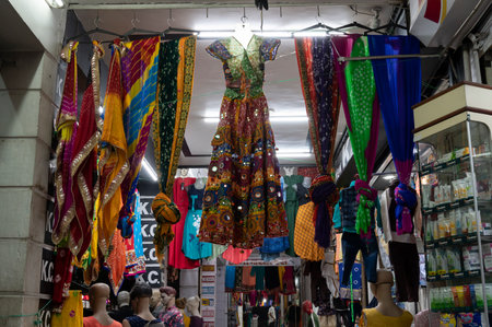 Jodhpur, Rajasthan, India - 19.10.2019 : Rajasthani womens clothes are hanging for sale , being displayed in a shop at famous Sardar Market and Ghanta ghar Clock tower in the evening.のeditorial素材