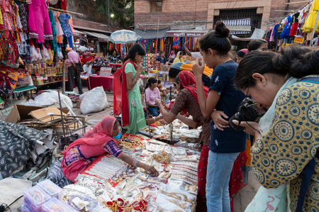 Jodhpur, Rajasthan, India - 20.10.2019 : White necklaces, gold plated earrings and ornaments are being sold to young female customers at famous Sardar Market and Ghanta ghar Clock tower in Jodhpur.のeditorial素材