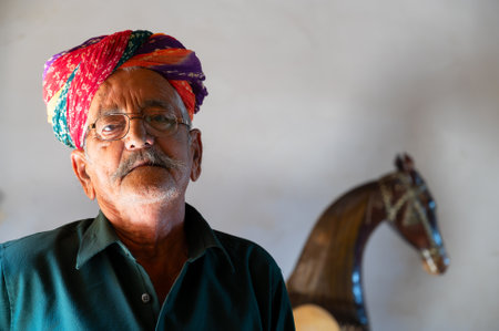 Jaisalmer, Rajasthan, India - 15th October 2019 : Portrait of caretaker of museum with colorful pagdi, pagari or turban , shot at museum of Rani Ka Mahal, Jaisalmer fort.のeditorial素材
