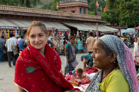 Jodhpur, Rajasthan, India - 20.10.2019 : Foreigners buying Rajasthani womens clothes being sold at Famous Sardar Market and Ghanta ghar Clock tower in the evening.のeditorial素材