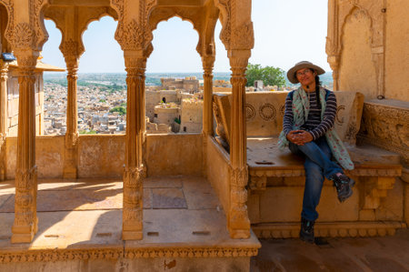 Jaisalmer, Rajasthan, India - 15th October 2019 : Happy female tourist on sandstone made beautiful balcony, jharokha, stone window and exterior of Rani Mahal or Rani Ka Mahal, inside Jaisalmer fort.のeditorial素材