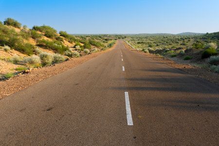 Morning in desert with empty high road or national high way passing through the desert. Distant horizon, Hot summer at Thar desert, Rajasthan, India.の写真素材