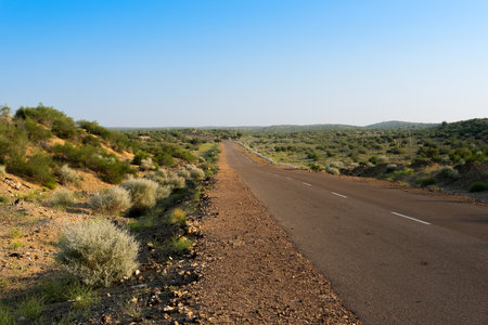 Morning in desert with empty high road or national high way passing through the desert. Distant horizon, Hot summer at Thar desert, Rajasthan, India.の写真素材