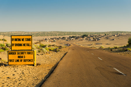 Milestone by BSF, Border security force, beside with empty high road or national high way passing through the desert. Distant horizon, Hot summer at Thar desert, Rajasthan, India.の写真素材
