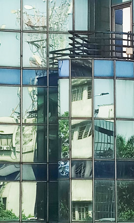 Abstract reflection of sky and city buidings on glass walls of another city building, Kolkata, West Bengal, India.の写真素材