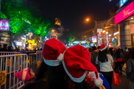 Kolkata, West Bengal, India - 26.12.2018 : Young ladies with red santa claus hats enjoying themselves at illuminated and decorated park street with lights with year end festive mood.のeditorial素材