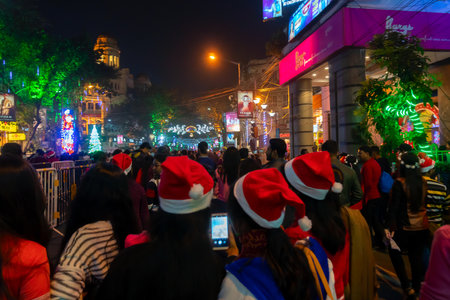 Kolkata, West Bengal, India - 26.12.2018 : Young ladies with red santa claus hats enjoying themselves at illuminated and decorated park street with lights with year end festive mood.のeditorial素材