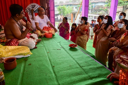 Howrah, West Bengal, India - 14th October 2021 : Hindu Purohit uttering Sanskrit shlokas for Hindu devotees offering pushpanjali to Goddess Durga, ritual to worship the Goddess with flowers.のeditorial素材