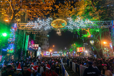 Kolkata, West Bengal, India - 25.12.2018 : Young people enjoying themselves at illuminated and decorated park street with lights with year end festive mood. Night sky background.のeditorial素材