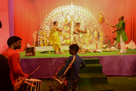 Howrah,India -October 13, 2021 : Dhaakis playing dhaaks while Hindu Priests worshipping Goddess Durga with panchapradip, chamor and hand fan. Ashtami puja aarati - sacred Durga Puja ritual.のeditorial素材