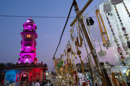 Jodhpur, Rajasthan, India - 19.10.2019 : Gold and silver plated ornaments are being sold at famous Sardar Market and Ghanta ghar Clock tower in afternoon. Blue hour.のeditorial素材