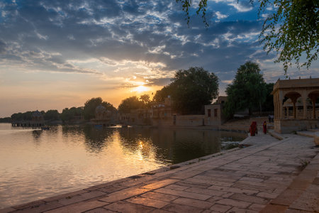 Sun sets behind main entrance of Gadisar lake, Jaisalmer, Rajasthan, India. Historical artifical lake, once only water resource for Jaisalmer city.のeditorial素材