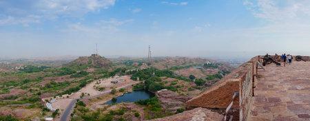 Panoramic view of Jodhpur city with car parking lot, mobile towers and water lake beside Mehrangarh fort, jodhpur, Rajasthan, India. Blue sky in the background.の写真素材