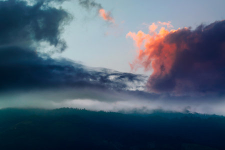 Spectacular sun set with colourful clouds in the sky beyond mountain peaks. Shot at Okhrey, Sikkim, India.の写真素材