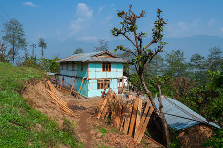 View of Sikkim village with affordable home stays for tourists, blue sky and Himalayan mountains in the background. Sikkim has a very thriving tourism industry based on tourists visiting Sikkim,India.の写真素材