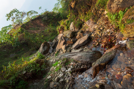 Water flowing downstraem, beautiful waterfall inside Himalayan forest, Sikkim, India. Sikkim has many scenic waterfalls flowing across the state and these falls are very popular tourist attraction.の写真素材