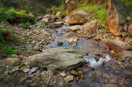 Water flowing downstraem, beautiful waterfall inside Himalayan forest, Sikkim, India. Sikkim has many scenic waterfalls flowing across the state and these falls are very popular tourist attraction.の写真素材