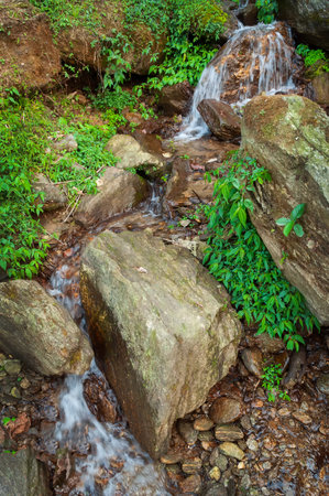 Water flowing through stones,beautiful waterfall inside Himalayan forest, Sikkim, India. Sikkim has many scenic waterfalls flowing across the state and these falls are very popular tourist attraction.の写真素材