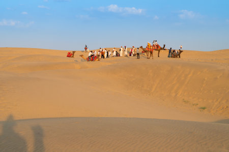 Tourists with camels, Camelus dromedarius, at sand dunes of Thar desert, Rajasthan, India. Camel riding is a favourite activity amongst all tourists visiting here.のeditorial素材