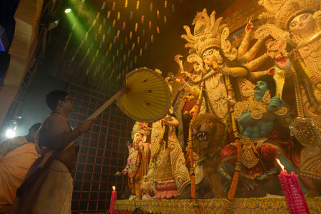 Howrah, West Bengal, India - 3rd October, 2022 : Hindu Priest worshipping Goddess Durga with big hand held fan. Ashtami puja aarati at night. Durga puja is unesco intangible cultural heritage.のeditorial素材