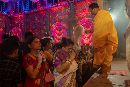 Howrah, West Bengal, India - 3rd October, 2022 : Hindu Bengali sari clad women praying to Goddess Durga inside Durga Puja pandal. Ashtami puja aarati at night. Biggest fetsival of Hinduism.のeditorial素材