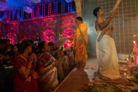 Howrah, West Bengal, India - 3rd October, 2022 : Hindu Bengali sari clad women praying to Goddess Durga inside Durga Puja pandal. Ashtami puja aarati at night. Biggest fetsival of Hinduism.のeditorial素材