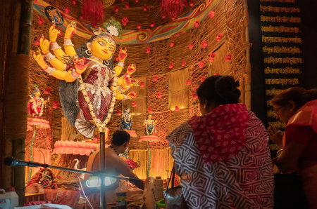 Howrah, West Bengal, India - 3rd October, 2022 : Hindu Purohit worshipping Goddess Durga with puja ingredients inside Durga Puja pandal. Durga Puja ritual. Biggest festival of Hinduism.のeditorial素材