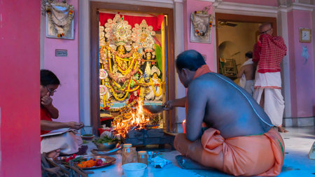 Howrah,West Bengal,India- 4th October, 2022 : Hindu Purohit raising fire of yajna to worship Goddess Durga for Ashtami puja aarati. Sacred Durga Puja ritual-festival of Hinduism. Festival of Hinduism.のeditorial素材