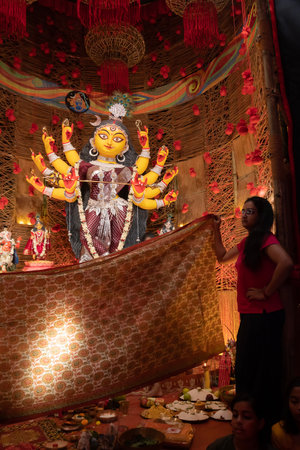 Howrah, West Bengal, India - 3rd October, 2022 : Hindu Purohit worshipping Goddess Durga with Vog, offering holy food for the Goddess behind cover. Durga Puja ritual. Biggest festival of Hinduism.のeditorial素材