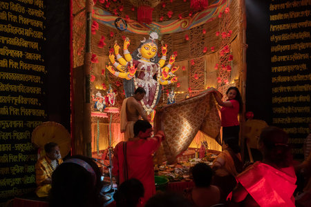 Howrah, West Bengal, India - 3rd October, 2022 : Hindu Purohit worshipping Goddess Durga with Vog, offering holy food for the Goddess behind cover. Durga Puja ritual. Biggest festival of Hinduism.のeditorial素材