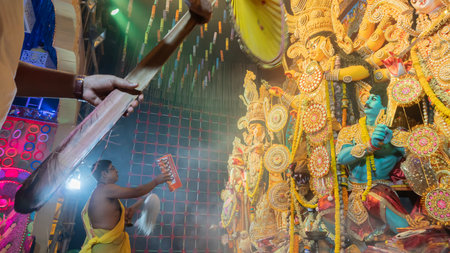 Howrah, West Bengal, India - 5th October, 2022 : Hindu Purohit worshipping Goddess Durga with Sari,...