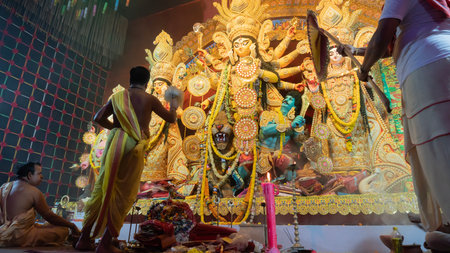 Howrah, West Bengal, India - 5th October, 2022 : Hindu Priest worshipping Goddess Durga with chamor, fly whisk fan. Ashtami puja aarati at night. Durga puja is unesco intangible cultural heritage.のeditorial素材