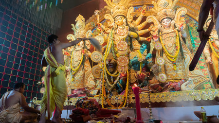 Howrah, West Bengal, India - 5th October, 2022 : Hindu Priest worshipping Goddess Durga with chamor, fly whisk fan. Ashtami puja aarati at night. Durga puja is unesco intangible cultural heritage.のeditorial素材