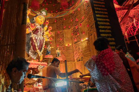 Howrah, West Bengal, India - 3rd October, 2022 : Hindu Purohit worshipping Goddess Durga with puja ingredients inside Durga Puja pandal. Durga Puja ritual. Biggest festival of Hinduism.のeditorial素材