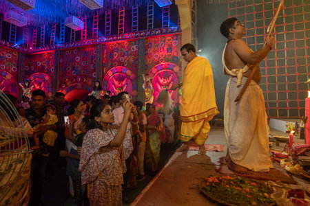 Howrah, West Bengal, India - 3rd October, 2022 : Beautiful girl child taking picture of Goddess Durga, inside Durga Puja pandal. Ashtami puja at night. Biggest fetsival of Hinduism. UNESCO heritage.のeditorial素材