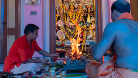 Howrah,West Bengal,India- 2nd October, 2022 : Hindu Purohit raising fire of yajna to worship Goddess Durga for Ashtami puja aarati. Sacred Durga Puja ritual-festival of Hinduism. Festival of Hinduism.のeditorial素材