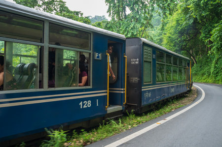 Darjeeling,West Bengal,India - 10th August 2023 : Diesel Toy train passing through Himalayan roads and jungle. Darjeeling Himalayan Railway, narrow gauge railway between New Jalpaiguri and Darjeeling.のeditorial素材
