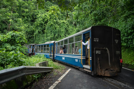 Darjeeling,West Bengal,India - 10th August 2023 : Diesel Toy train passing through Himalayan roads and jungle. Darjeeling Himalayan Railway, narrow gauge railway between New Jalpaiguri and Darjeeling.のeditorial素材