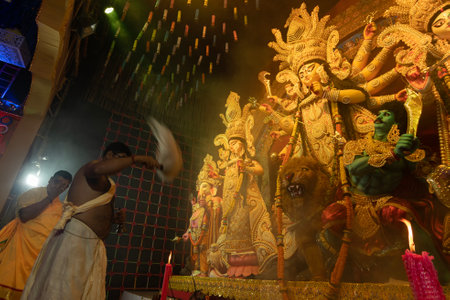 Howrah, West Bengal, India - 3rd October, 2022 : Hindu Priest worshipping Goddess Durga with chamor, fly whisk fan. Ashtami puja aarati at night. Durga puja is unesco intangible cultural heritage.のeditorial素材