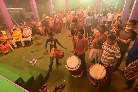 Howrah, West Bengal, India -October 13, 2021 : Dhaakis playing dhaaks while Hindu Priests worshipping Goddess Durga. Ashtami puja aarati - sacred Durga Puja ritual.のeditorial素材