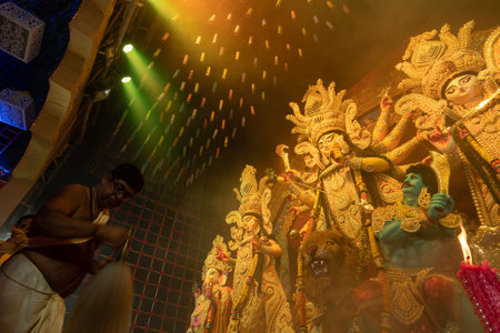 Howrah, West Bengal, India - 3rd October, 2022 : Hindu Priest worshipping Goddess Durga with chamor, fly whisk fan. Ashtami puja aarati at night. Durga puja is unesco intangible cultural heritage.のeditorial素材