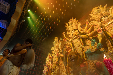 Howrah, West Bengal, India - 3rd October, 2022 : Hindu Priest worshipping Goddess Durga with chamor, fly whisk fan. Ashtami puja aarati at night. Durga puja is unesco intangible cultural heritage.のeditorial素材