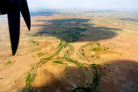 View of Thar desert from an aeroplane, Rajasthan, India. The propellers and thar desert in the frame. Play of sun light and clouds shadow on the desert below.の写真素材