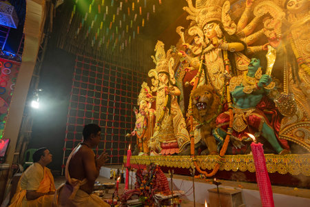 Howrah,West Bengal,India- 3rd October, 2022 : Hindu Priests praying and worshipping Goddess Durga with folded hands, kneels down position.Puja Pandal.Durga puja is unesco intangible cultural heritage.のeditorial素材