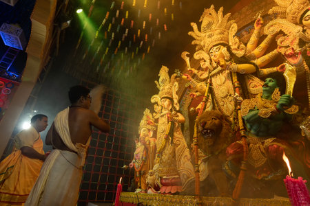 Howrah, West Bengal, India - 3rd October, 2022 : Hindu Priest worshipping Goddess Durga with chamor, fly whisk fan. Ashtami puja aarati - Durga Puja ritual- festival of Hinduism being performed.のeditorial素材