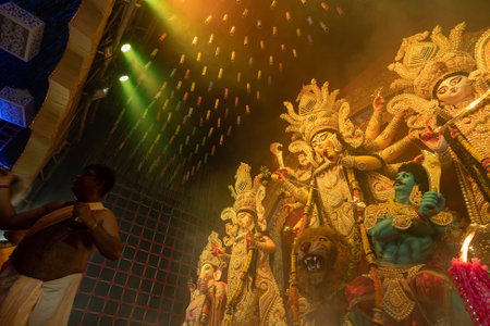 Howrah, West Bengal, India - 3rd October, 2022 : Hindu Priest worshipping Goddess Durga. Ashtami puja aarati - Durga Puja ritual- festival of Hinduism being performed inside pandal at night.のeditorial素材