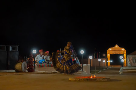Thar desert, Rajasthan, India - October 15th 2019 : Rajasthani female dancer dancing, dressed with cultural dress of Rajasthan, at night. Male Musicians are playing music instruments in background.のeditorial素材