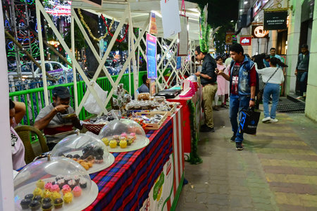 Kolkata, West Bengal, India - 24.12.2023 : Citizens enjoying delicious food and snacks at food court during Christmas at Park street. People visit Park street to enjoy festive mood during Christmas.のeditorial素材